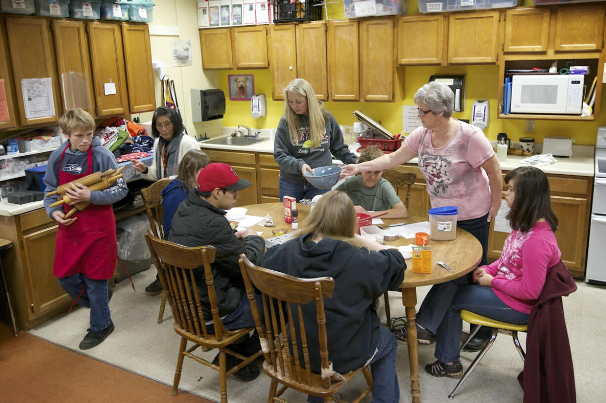 Justin Hanson, left, a Prairie High School student with special needs, carries an armload of rolling pins from the life skills kitchen in one classroom to an adjacent classroom. The life skills program's three classrooms serve 32 students with special needs.