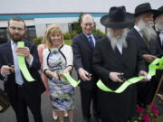 Photos by STEVEN LANE/The Columbian
Rabbi Shmulik Greenberg, from left, Kate Rifkin, Marty Rifkin, Rabbi Levitin of Seattle, Rabbi Wilhelm of Portland, and Rabbi Wolff of Morristown, N.J., on Sunday join in the ribbon- cutting at the newly remodeled Chabad Jewish Center.