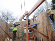 Crews place roof beams in the Emerald House project, which was designed to showcase a series of environmentally friendly features.