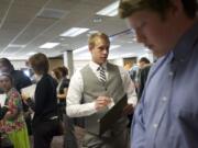 Braden Lewallen, 22, of Camas, who graduated from Washington State University with a political science degree, gets in line to talk to recruiters at a job fair hosted by Rep. Jamie Herrera Beutler at the Red Lion at the Quay on June 10.