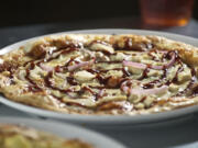 A Lucy Sunshine pizza, foreground, and a Caspian pizza and a caramelized pear iced tea at MOD Pizza.