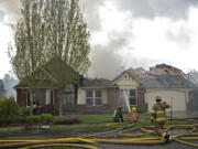 Firefighters work to extinguish a fire that destroyed a Camas house Tuesday afternoon.