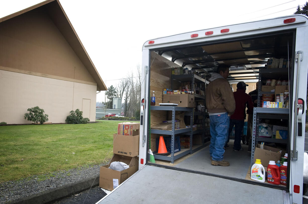 A family picks out food from the Lewis River Mobile Food Bank trailer which visited the La Center Free Evangelical Church in January 2011.