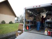 A family picks out food from the Lewis River Mobile Food Bank trailer which visited the La Center Free Evangelical Church in January 2011.