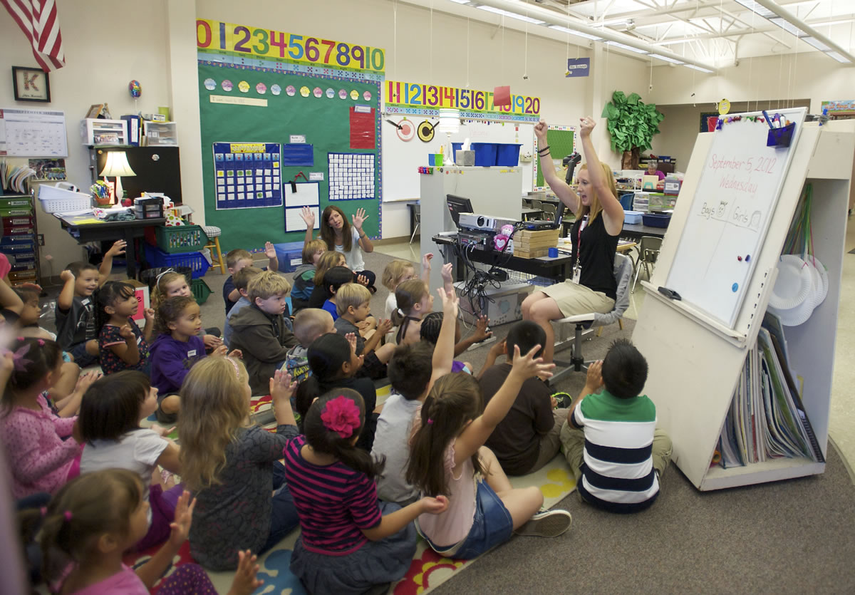 Becky Kornell, right, welcomes kindergartners to her class this morning on the first day of school at Lincoln Elementary.