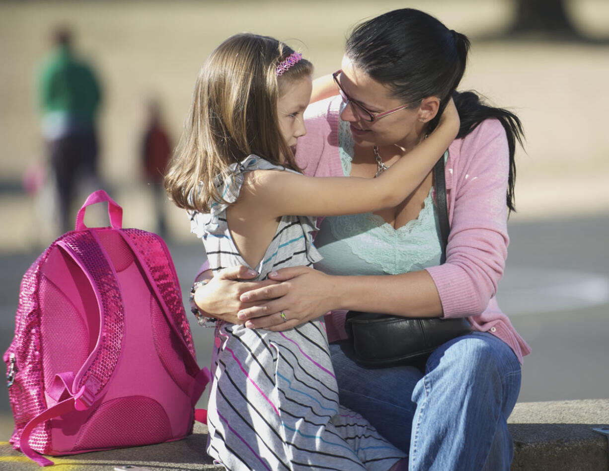 Rebecca Wescom-Farmer hugs her daughter Sophia Farmer, 6, while seeing her off on the first day of school at Lincoln Elementary on Wednesday.