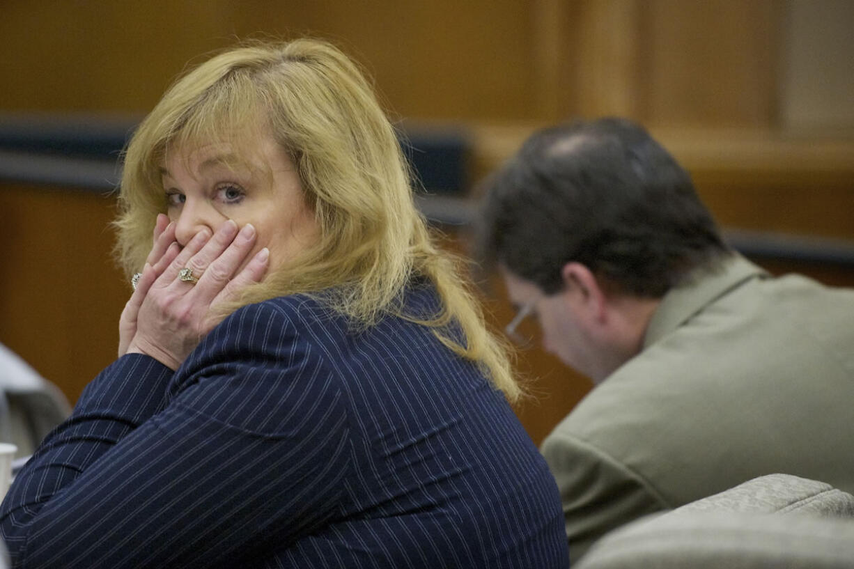 Sandra Weller, left, and Jeffrey Weller, background, wait for the start of their trial Tuesday in Vancouver on charges that they imprisoned, starved and beat their adopted twins.