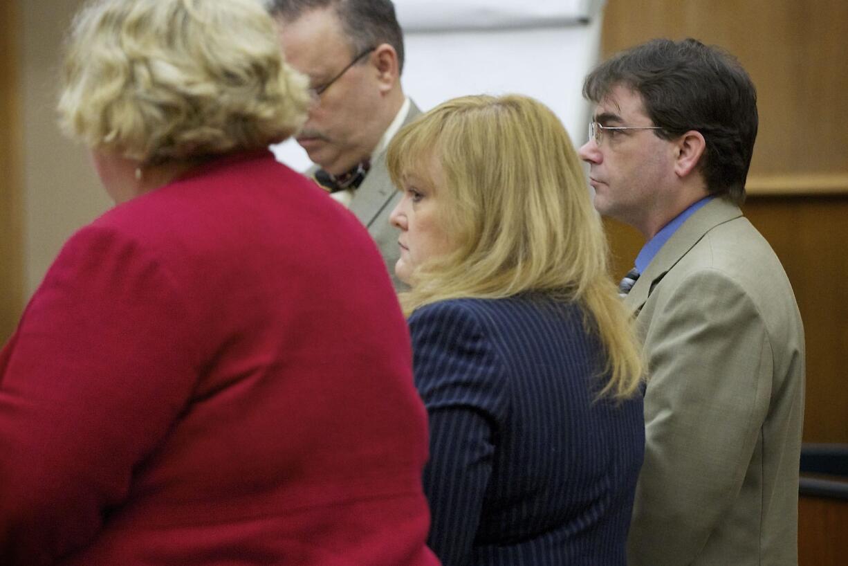 Sandra Weller, center, and Jeffrey Weller, background right, stand as the jury enter the courtroom for the start of their trial on Tuesday.