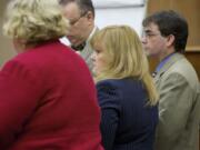 Sandra Weller, center, and Jeffrey Weller, background right, stand as the jury enter the courtroom for the start of their trial Tuesday.