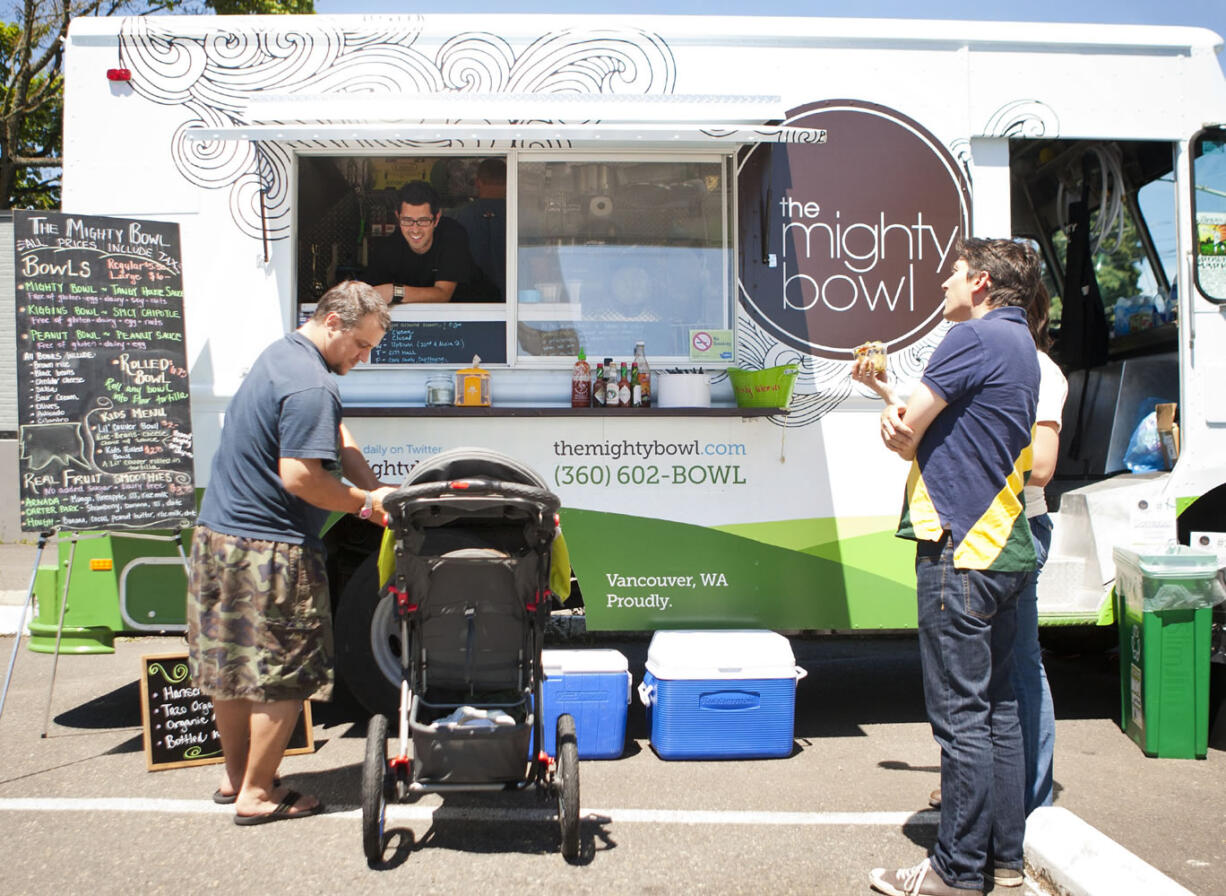 Customers gather at The Mighty Bowl, the first mobile food truck in Vancouver, at the intersection of East 22nd and Main streets at lunch on Wednesday.