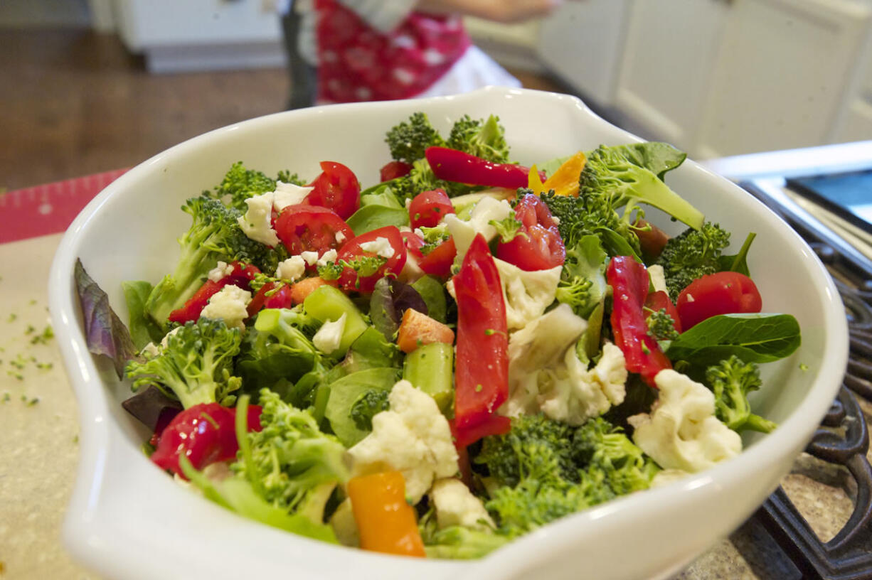 The Puyleart family uses fresh produce, purchased through community supported agriculture programs at Clark County farms, to make a dinner salad at their La Center home.