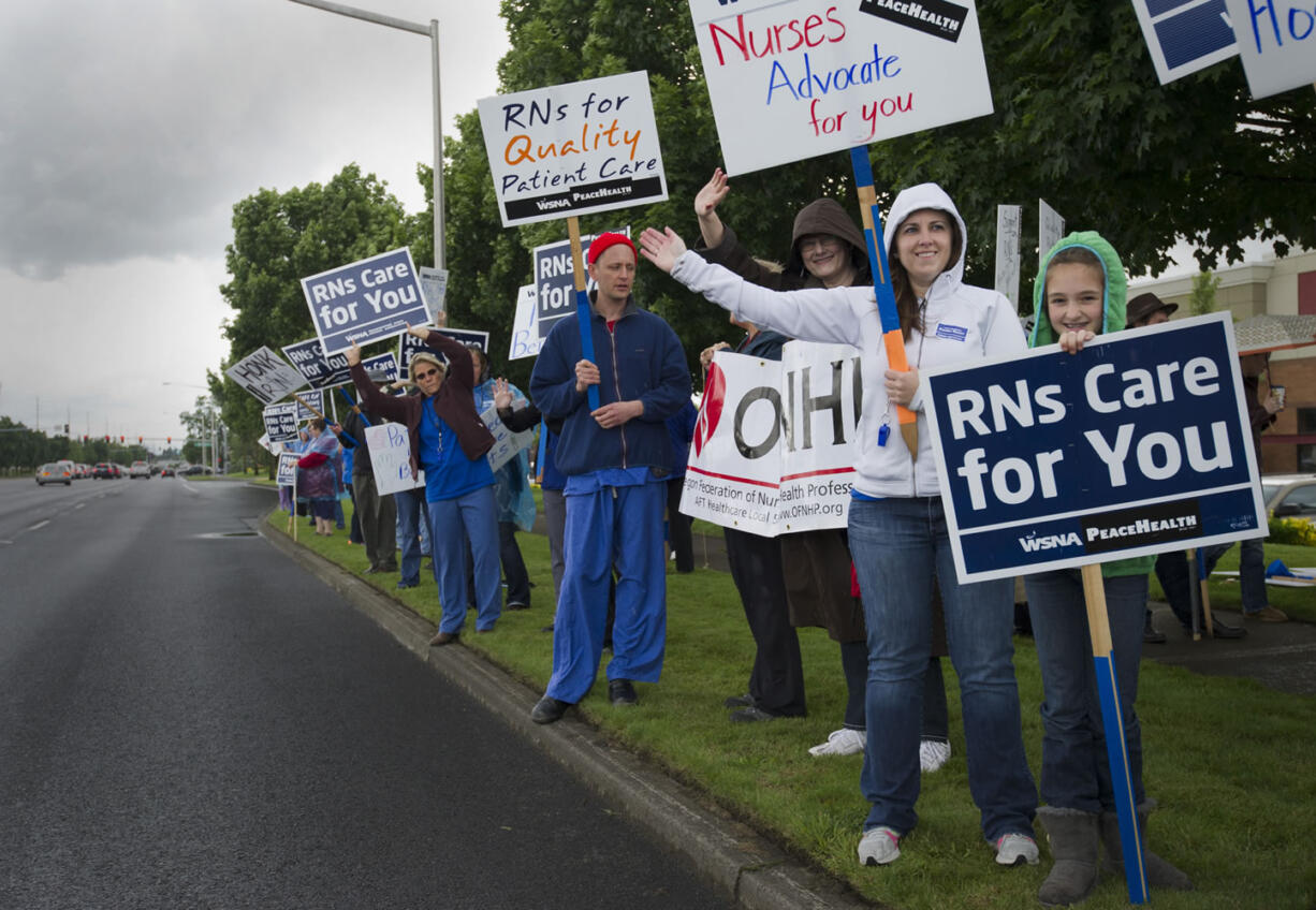 Amy Gilmore and her daughter, Lily Hooper, right, participate in the union nurses protest outside the PeaceHealth headquarters in Vancouver on Wednesday.