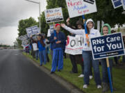 Amy Gilmore and her daughter, Lily Hooper, right, participate in the union nurses protest outside the PeaceHealth headquarters in Vancouver on Wednesday.