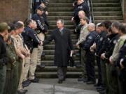 Officers from the Vancouver Police Department and Clark County Sheriff's Office line the stairs and walkway outside the Clark County Courthouse Friday afternoon to give Judge John Wulle a surprise send-off on his last day presiding as judge.