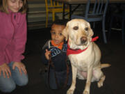 Esther Short: Emma Ellard, left, lets a young boy greet her dog, Luna, during the &quot;Read to a Guide Dog Puppy&quot; event held Jan. 12 at the Vancouver Community Library.