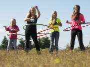 Trina Latshaw, second from left, creator of Phat Hoops, and her daughters, from left, Jordan, 9, Julia, 13, and Madison, 19, demonstrate the fitness hoops Tuesday.