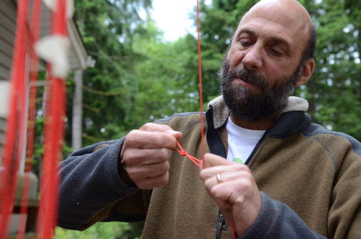 Joe Barbera inspects part of the rigging for his manned lawn chair flight attempt.