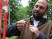 Joe Barbera inspects part of the rigging for his manned lawn chair flight attempt.