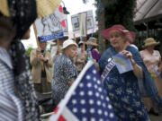 A group associated with the Democratic Women's Club of Clark County gathers outside the Red Lion Hotel at the Quay on Monday before walking along the Columbia River Waterfront to celebrate the 19th Amendment.