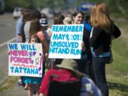 Coworkers, who worked with Tatyana at an assisted living facility in Battle Ground, hold signs facing Highway 503 to remind people of Tatyan's unsolved death.