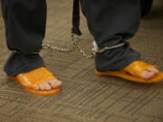 An inmate shuffles into Clark County Superior Court earlier this spring, wearing shackles and orange plastic sandals.