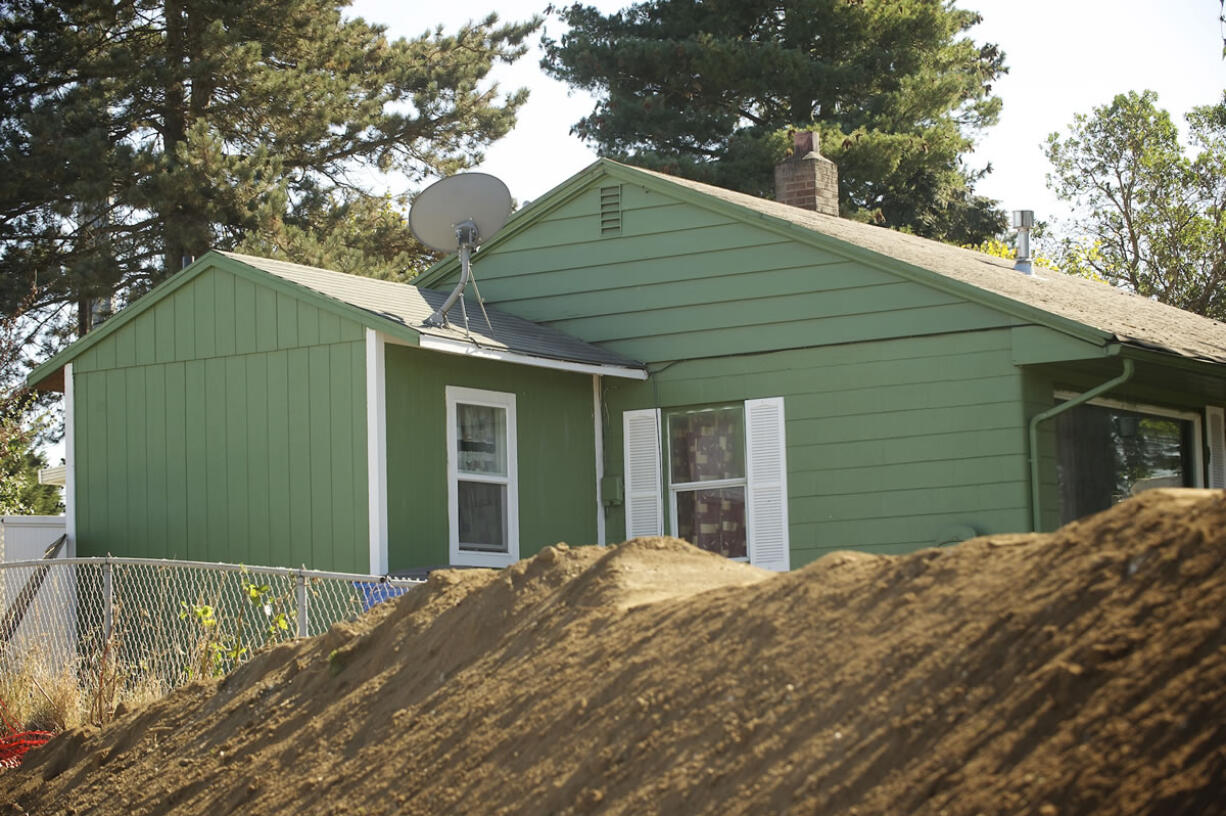 A noise-reducing soil berm is being constructed between a new offramp and Joel and Melissa Dodge's home in the Rose Village neighborhood.