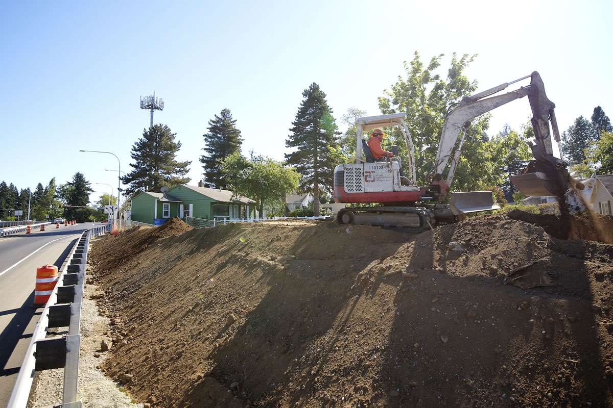 Dan Weissenfluh with Tapani Underground moves dirt to build a noise-reducing berm near the new state Highway 500 interchange at St. Johns Boulevard.