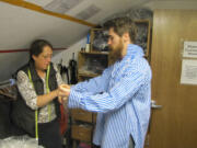 Sheila Dolle checks the fit as re-enactor Ethan Hardy tries on a shirt.