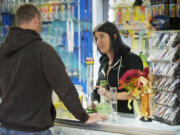 Steven Lane/The Columbian
Employee Karsen Stamp, 23, helps a customer Thursday at Mary Jane's House of Glass, which sells pipes commonly used for smoking marijuana.