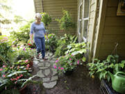 Teri Clark walks through her shade garden, one of many she keeps us with husband Bob.