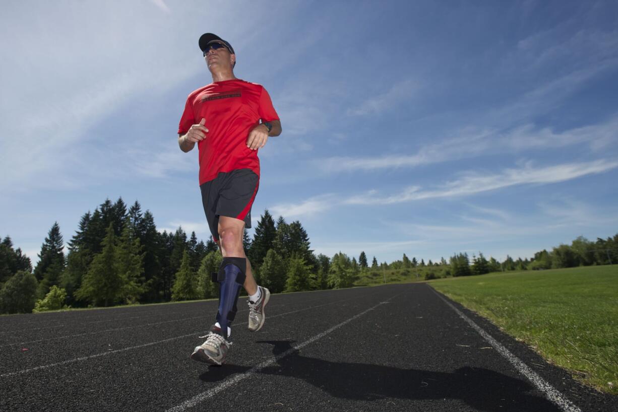 Camas resident Darren Smith runs a workout on the track at Skyridge Middle School on Wednesday. Smith, 47, is a paratriathlete.