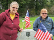 Battle Ground: Karly Dockter, left, and Anita Daniels stand by the grave of World War I veteran George A. McCollum on Nov. 9.