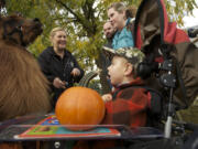 Three-year-old Owen Miles greets therapy llama Rojo without words Sunday at a fundraiser for Sensory Camp.