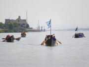 Canoes from the Cowlitz, Warm Springs, Snohomish, Clatsop-Nehalem and Snoqualmie tribes approach the welcoming party Tuesday on the Columbia River just east of Who Song &amp; Larry's.