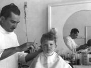 Cecil Wright cuts the hair of a boy whose last name is Potter in August 1947.