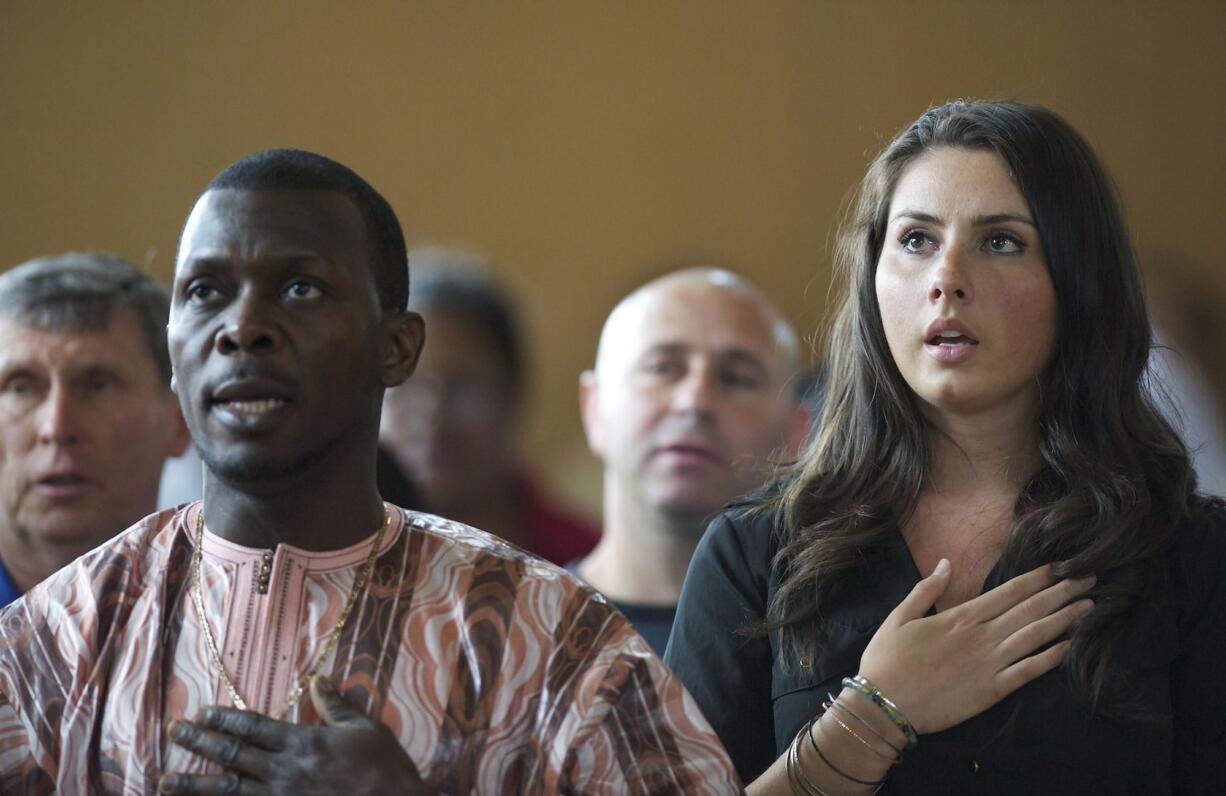 Diana Gensitskaya sings the National Anthem as she becomes a U.S. citizen on Thursday at a naturalization ceremony at the Immigrant and Refugee Community Organization in Portland. Gensitskaya, 23, came to the United States from Ukraine when she was a baby.