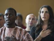 Diana Gensitskaya sings the National Anthem as she becomes a U.S. citizen on Thursday at a naturalization ceremony at the Immigrant and Refugee Community Organization in Portland. Gensitskaya, 23, came to the United States from Ukraine when she was a baby.