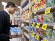 Matt Brown, a supervisor at the Salmon Creek Safeway, inspects infant formula in a locked case Tuesday.