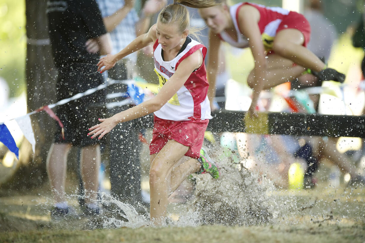 Mark Morris varsity girl cross country runners leap over an obstacle into a water pit during the 51st annual Hudson's Bay High School Run-A-Ree Friday in Vancouver.