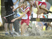 Mark Morris varsity girl cross country runners leap over an obstacle into a water pit during the 51st annual Hudson's Bay High School Run-A-Ree Friday in Vancouver.