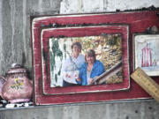 A framed photo sits on the metal edge of a dry erase board inside a burned-out classroom.