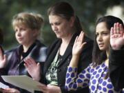 Sindhu Koirala, right, of Nepal recites the Oath of Allegiance during a U.S. Citizenship and Immigration Services naturalization ceremony Friday at the Fort Vancouver National Historic Site. She was among 29 people to become new U.S.