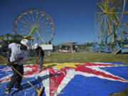 Butler Amusements carnival workers Andrew Jackson, foreground, 44, and Roosevelt Conley, 39, wash the top for the small carousel in preparation for the Clark County Fair.