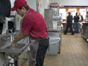 KFC team member Johnny Garcia, 22, washes his hands inside the Hazel Dell quick-service venue.