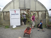 Nhu Rakoz, with her son, Edward, 4, pulls a wagon at the Mother's Day plant sale at the Heritage Farm on Sunday.