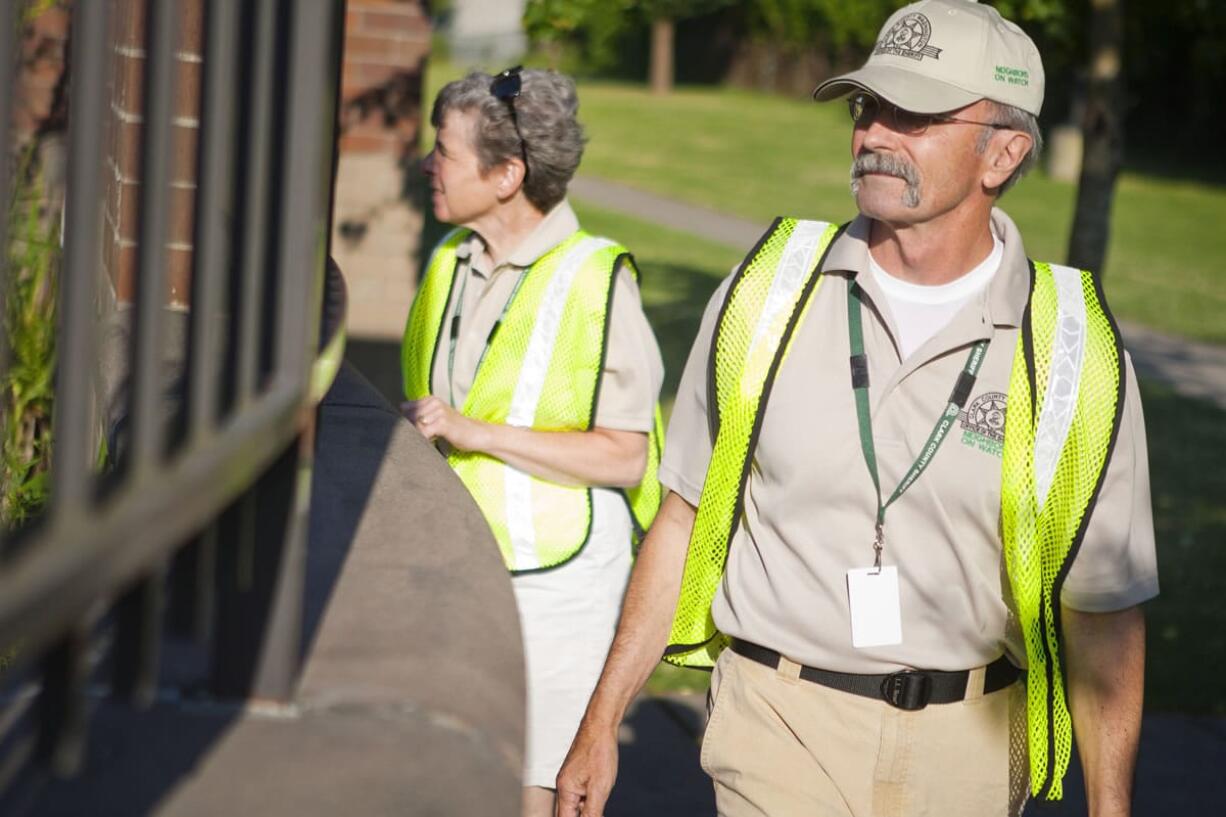 Kim Evans, legt, and Dan Enright walk outside Hazel Dell Elementary as they patrol Hazel Dell on Tuesday.