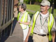 Kim Evans, legt, and Dan Enright walk outside Hazel Dell Elementary as they patrol Hazel Dell on Tuesday.