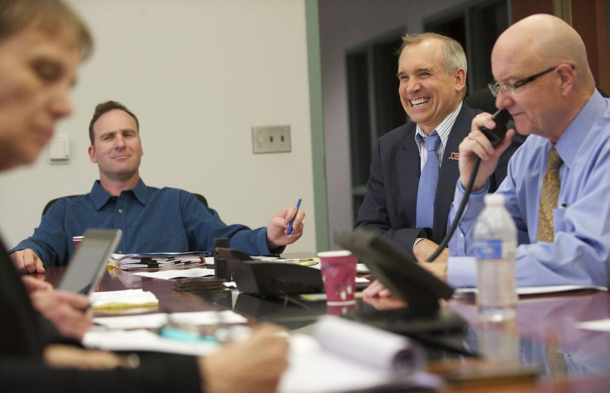 Clark County Commissioners Steve Stuart, from left, David Madore and Clark County Administrator Bill Barron, along with staff members and members of the public, meet at the Clark County Public Service Center on Wednesday.