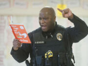 With a booming voice, Vancouver police Officer Rey Reynolds reads &quot;Green Eggs and Ham&quot; to a class of second-graders at Mill Plain Elementary School. The monthly event is put on by the Police Activities League, which promotes relationships between law enforcement and youth.