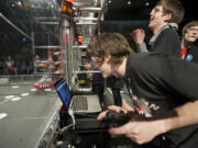 Mean Machine members (from left) co-pilot Ryan Berg, 16; commander/team captain Keefe Koenig, 18; and pilot Bryce Croucher, control their disc-shooting robot in Friday's regional challenge at Veterans Memorial Coliseum in Portland.